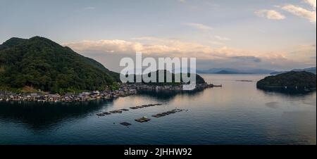 Panoramic view of Ine fishing village and floating docks in bay at sunset Stock Photo