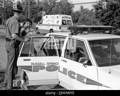 Troy Scott Stephens, 32, of 2710 E. Hwy. 619 (right), tries and fails to intimidate a news photographer as Russell Springs Police Department Patrolman Daniel Garland places him under arrest following an alleged domestic violence incident on Monday, June 3, 1996 in Russell Springs, Russell County, KY, USA. The charges were later dismissed, according to court records, but Stephens was arrested again on July 13, 1996 for allegedly assaulting his estranged wife and one other person, then hitting a deputy sheriff in the head multiple times with a flashlight. (Apex MediaWire Photo by Billy Suratt) Stock Photo