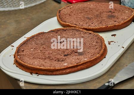 Chef cuts the chocolate cake in two to make pear and walnut pie Stock Photo
