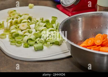 Chopped leeks and carrots on plate for cooking Stock Photo