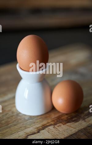 Boiled egg on stand and on a wooden board in the morning Stock Photo