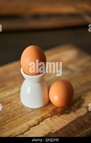 Boiled egg on stand and on a wooden board in the morning Stock Photo