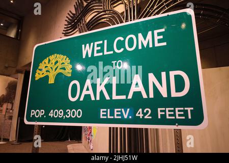 A green, metal, street, road, highway sign, Welcome to Oakland. At the Oakland Museum of Art in Oakland, California. Stock Photo