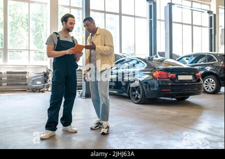 Two men looking at tablet standing in workshop Stock Photo
