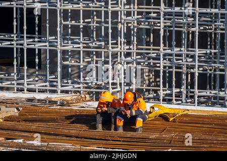 Unrecognizable builders using smartphones during break Stock Photo
