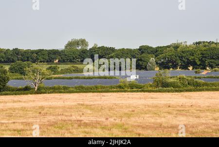 Lewes UK 19th July 2022 - A solar panel farm near Arlington Reservoir soaks up the sun during the heatwave weather today as an extreme red weather warning has been issued for today throughout parts of Britain : Credit Simon Dack / Alamy Live News Stock Photo