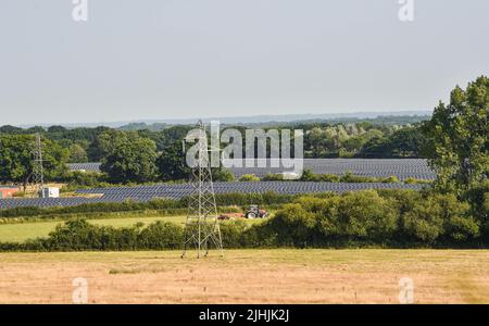 Lewes UK 19th July 2022 - A solar panel farm near Arlington Reservoir soaks up the sun during the heatwave weather today as an extreme red weather warning has been issued for today throughout parts of Britain : Credit Simon Dack / Alamy Live News Stock Photo