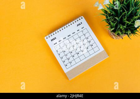 July 2023 desk calendar on yellow background. Directly above. Flat lay. Stock Photo