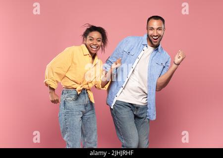 Having fun. Portarit of overjoyed african american couple dancing and fooling around, enjoying favorite music together Stock Photo
