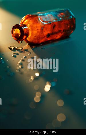 Antique retro medical brown orange bottle on blue background with liquid droplets Stock Photo