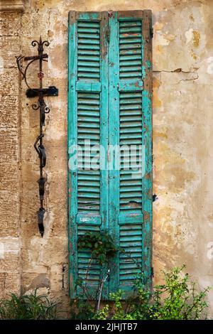 Worn wooden window shutters on the shabby orange wall Stock Photo