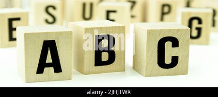 A B C letters on wooden cubes against white background Stock Photo