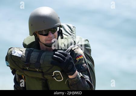Waldeck, Germany. 19th July, 2022. A parachutist of the German Army's Signal Company Division Fast Forces (DSK) comes out of the Edersee after an exercise. On the surface of the Edersee the 'emergency procedure water landing' is trained. Credit: Swen Pförtner/dpa/Alamy Live News Stock Photo