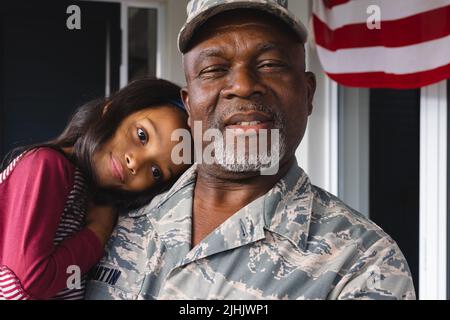 Portrait of african american military senior man carrying and cuddling biracial granddaughter Stock Photo