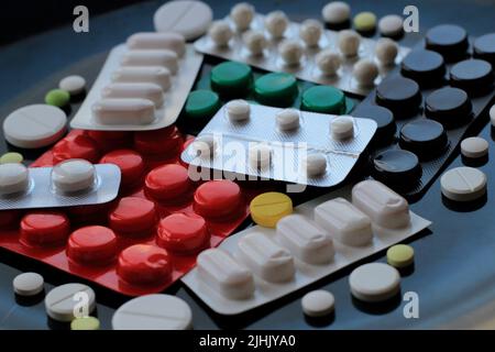 Tablets in different blisters and packages isolated on black surface Stock Photo