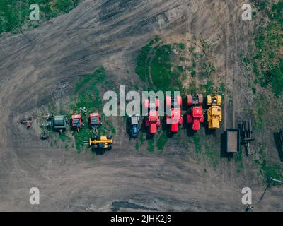 Modern agricultural machinery for farming. Many different tractors standing in row. Agribusiness leasing. Drone view Stock Photo