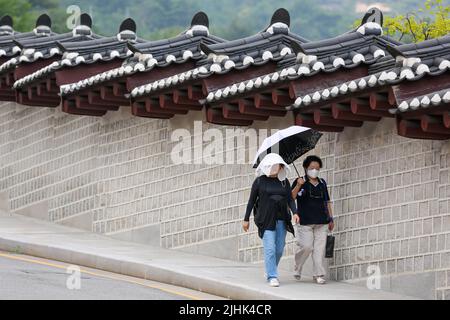 Seoul, South Korea. 19th July, 2022. People holding an umbrella walk on a street in Seoul, South Korea, July 19, 2022. Credit: Wang Yiliang/Xinhua/Alamy Live News Stock Photo