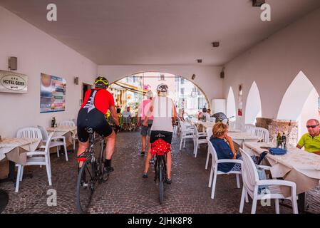 Cyclists on the boardwalk. Promenade of Torbole. Nago–Torbole is a comune, municipality, in Trentino in the northern Italian region Trentino-Alto Adig Stock Photo