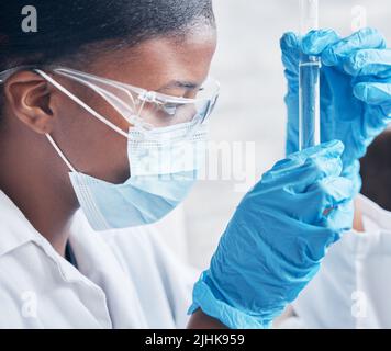Doing all she can to perfect a working cure. a young scientist working with test tubes in a lab. Stock Photo