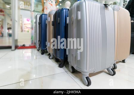 Close-up of gray, blue, beige suitcases in the store. Luggage bags in the store. Sale of suitcases for trips Stock Photo