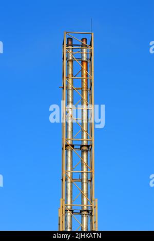 few high industrial silver pipe pylone on blue sky in sunny day, modern industry diversity Stock Photo