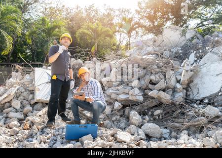 Demolition control supervisor and contractor using tablet to planning on demolish building. Stock Photo