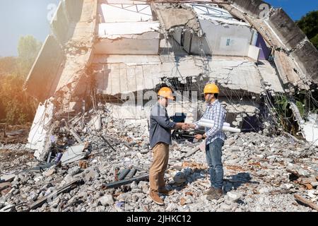 Engineers shaking hands in demolish building. Agreement between structural engineers and contractors after agreeing the cost of construction and repai Stock Photo