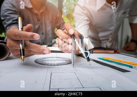 Engineer or architect meeting for project working with partner and using divider compass tools on blueprint in office on site. Stock Photo