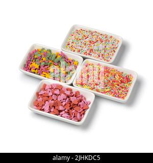 Small bowls with colorful sugar sprinkles to decorate homemade pastry isolated on white background Stock Photo