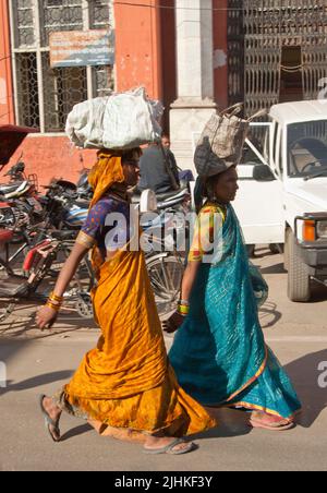 Women carry on head while walking, India Stock Photo