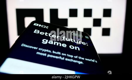 Mobile phone with website of crypto company Aux Cayes FinTech Co. Ltd. (OKX) on screen in front of logo. Focus on top-left of phone display. Stock Photo