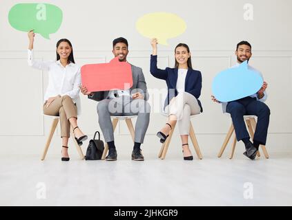 Group of diverse businesspeople holding speech bubble while waiting for interview. Team of applicants together. Candidates in line for job opening Stock Photo