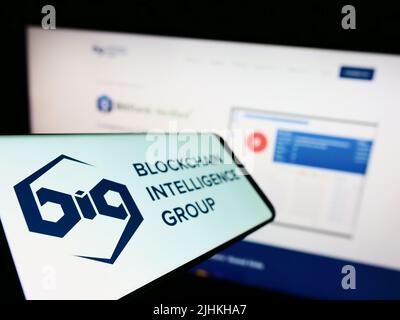 Cellphone with logo of Canadian company Blockchain Intelligence Group (BIG) on screen in front of website. Focus on left of phone display. Stock Photo