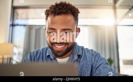 Happy businessman online on his laptop. Young entrepreneur using his laptop at home. Freelance virtual worker planning on his computer at home Stock Photo