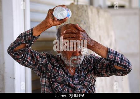 Baghdad, Iraq. 19th July, 2022. An Iraqi man cools off by pouring water over his head amid an ongoing heatwave in Iraq. Iraq experiences a heatwave with temperatures soaring to over 45 degrees Celsius. Credit: Ameer Al-Mohammedawi/dpa/Alamy Live News Stock Photo