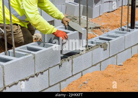 There was a mason who was laying the mounting to the aerated concrete blocks of the wall Stock Photo