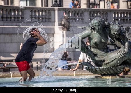 London, UK, 19/07/2022, London Heatwave A tourist cools off in one of the fountains at Trafalgar Square today as temperatures reach 37C in some of the hottest weather to ever hit the United Kingdom. 19th July 2022 London, UK Stock Photo