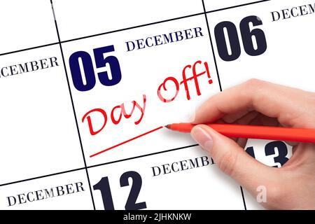 5th day of December. Hand writing text DAY OFF and drawing a line on calendar date 5 December. Vacation planning concept. Winter month, day of the yea Stock Photo