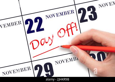 22nd day of November. Hand writing text DAY OFF and drawing a line on calendar date 22 November. Vacation planning concept. Autumn month, day of the y Stock Photo