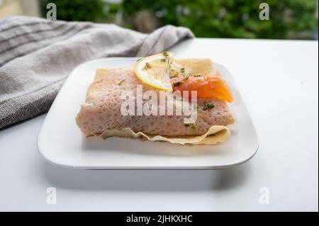 Cuisine of Normandy, galette pancake filled with goat cheese and smoked salmon served with fresh lemon, France Stock Photo