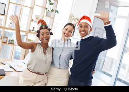 Portrait of three joyful businesspeople celebrating at a festive party together at work. Happy colleagues looking cheerful at a christmas office party Stock Photo