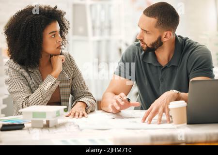 Focused colleagues working on a project together. Young architects working together in an office. Businesspeople working in a design agency Stock Photo
