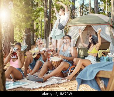 This is why were all friends. Full length shot of a diverse group of friends sitting and bonding during a day in the woods. Stock Photo