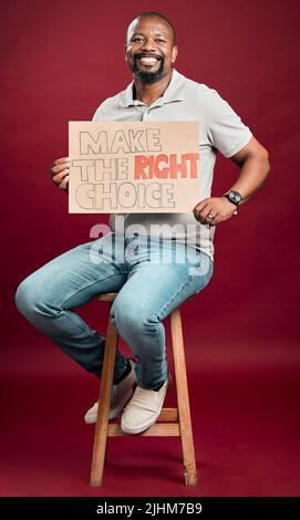 African american covid vaccinated man showing and holding poster. Smiling black man isolated against red studio background with copyspace. Happy model Stock Photo