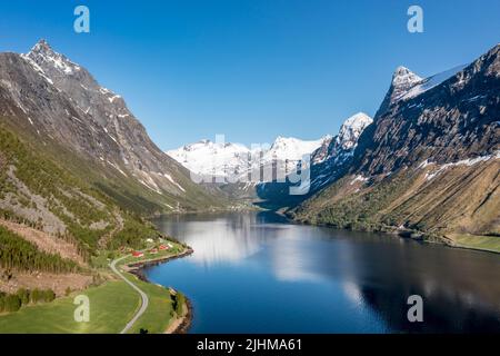 Aerial panoramic view over fjord Hjorundfjord towards village Oye at end of fjord, mt. Slogen (left), Norway Stock Photo