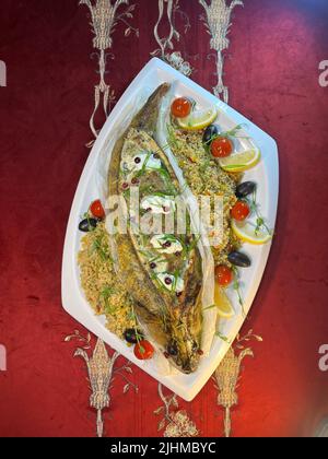 whole fish baked pike perch on a white plate top view. Stock Photo