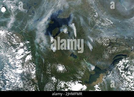 A satellite image showing smoke from wildfires burning across the Yukon and Northwest Territories of Canada, detected by the NASA Landsat 8 Satellite, July 6, 2022, in Earth Orbit. According to the Canadian government, 136 fires were burning in the Yukon and 65 in the Northwest Territories. Stock Photo
