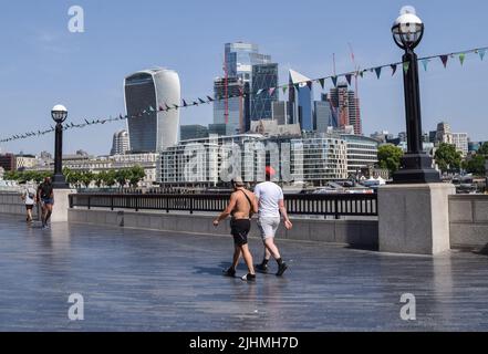London, UK. 19th July, 2022. A couple walks past the City of London skyline next to Tower Bridge as the UK records its highest ever temperatures. The Met Office has issued its first-ever red warning over extreme heat in the UK. (Credit Image: © Vuk Valcic/SOPA Images via ZUMA Press Wire) Stock Photo