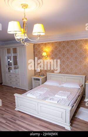 luxury room with vintage wallpaper and a double bed. fresh bed linen. Stock Photo