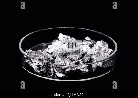 Chromium fragments, industrial use ore, metallic chemical element, isolated on black background inside a petri dish Stock Photo